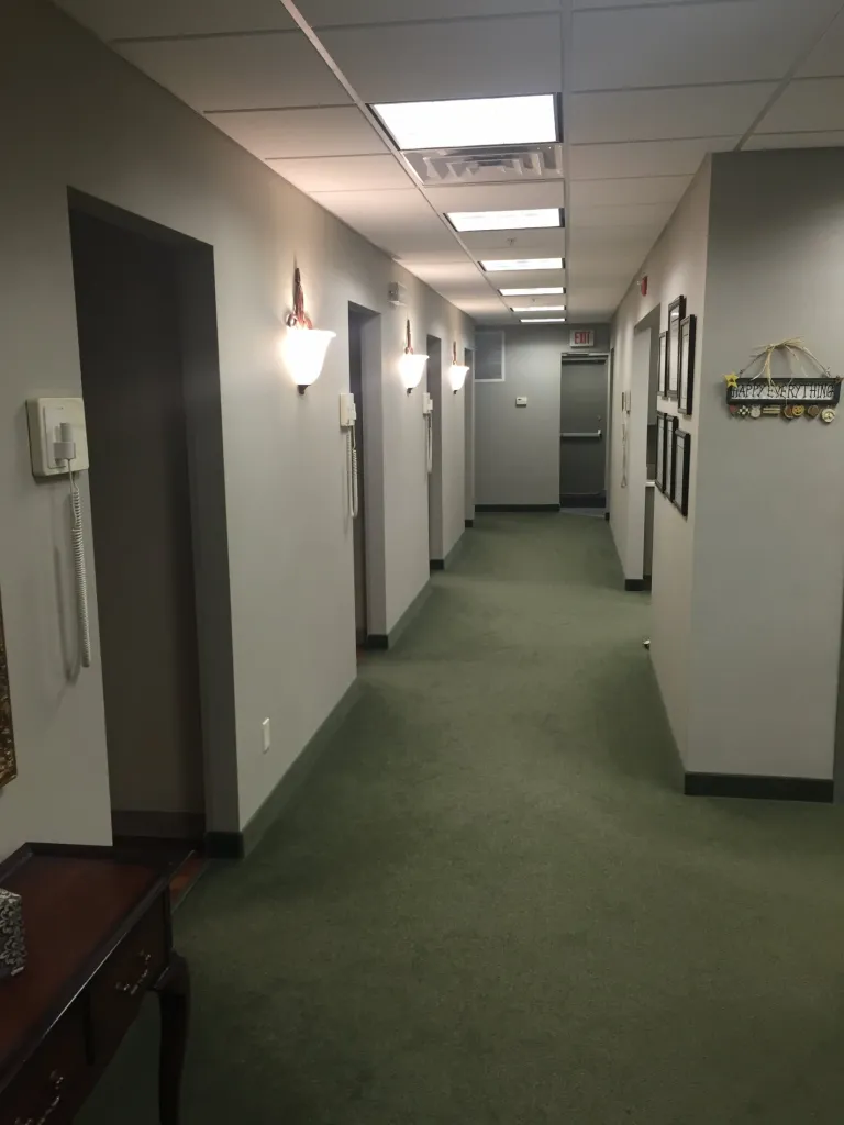 Hallway that leads to the patient treatment rooms in [PRACTICE_NAME] office n [CITY] [STATE], where a range of [SPECIALTY] treatments and surgeries are performed.